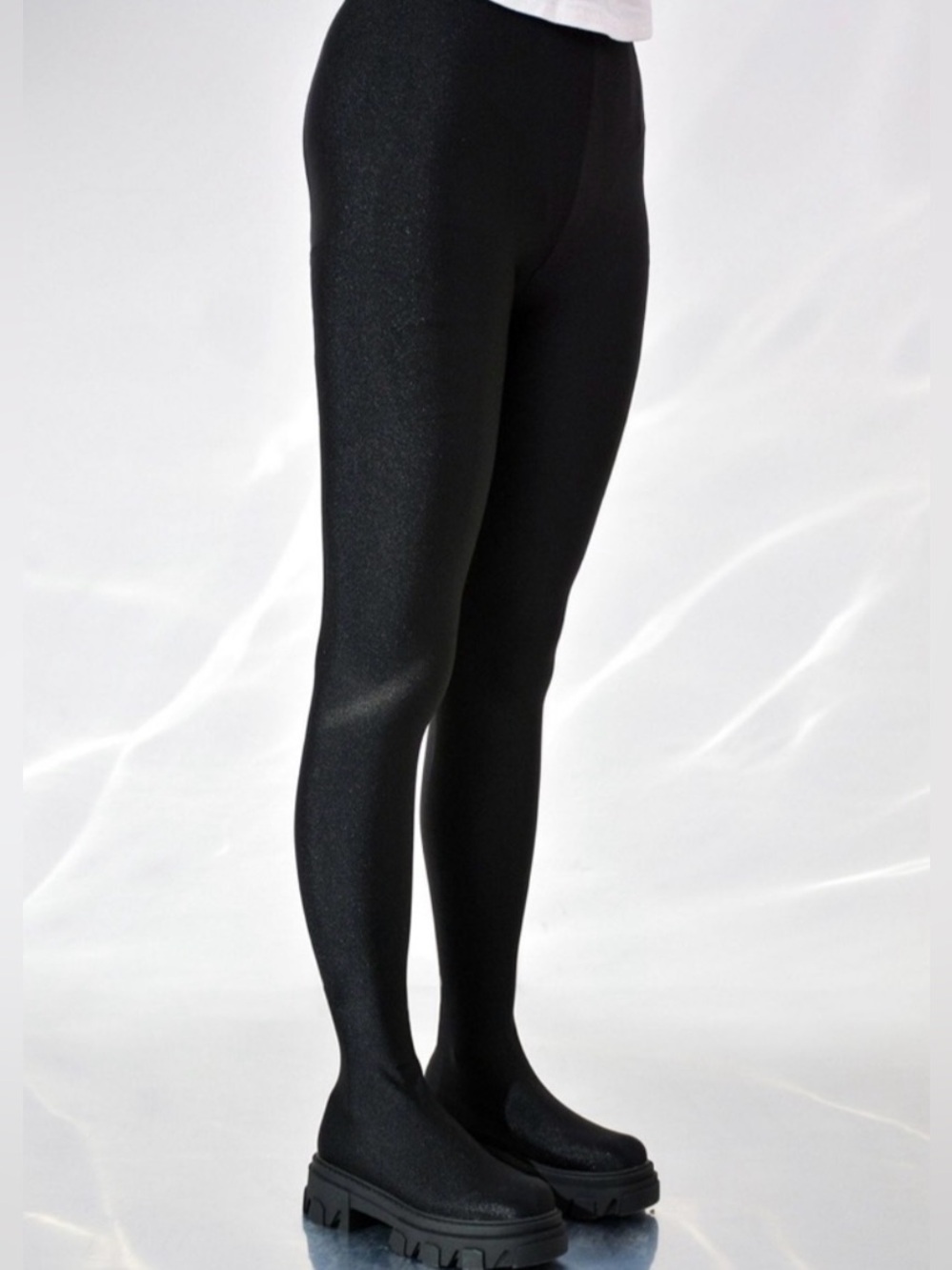 Pant boots featuring a shiny black material leggings and a chunky lug sole.